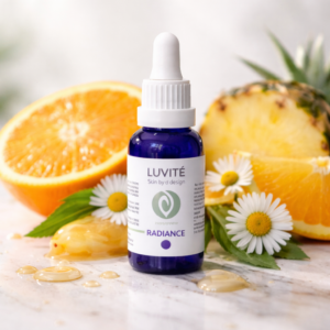 Luvité Radiance serum with citrus fruits and flowers on bright natural surface