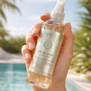 Luvité SPF 20 sun spray being applied in a fine mist, showcasing a lightweight sunscreen formula for easy, even coverage and daily sun protection